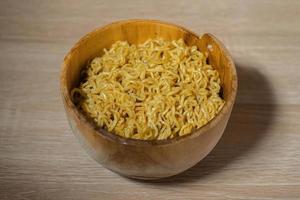 Fried instant noodles on a wooden bowl and wooden table photo
