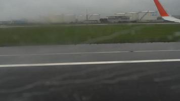 vista desde el avión en el aeropuerto a través de la ventana con gotas de lluvia y arroyos video