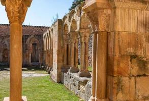 Romanesque monastery courtyard with stone arches photo
