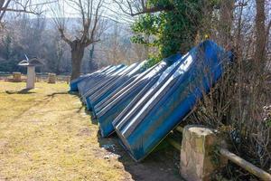 wooden boats stacked on the lawn outside the pier photo