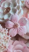 Close up Thai dessert various flower shaped in pastel pink color tone of Coconut milk flavor, Sam Pan Nee traditional Thai handcraft snack, Royal famous Thai sweets, vertical image  for wallpaper photo