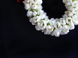 cerca arriba parte de tailandés tradicional estilo, jazmín guirnalda, símbolo de madre día, homenaje a un Buda jazmín, Malai, Arte diseño, en oscuro antecedentes con blanco Copiar espacio foto