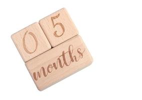 A wooden block showing the date of birth of a newborn child on a white background. photo