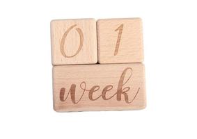 A wooden block showing the date of birth of a newborn child on a white background. photo