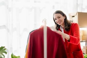 young woman work for checking the clothes in the home, concept e commerce. photo