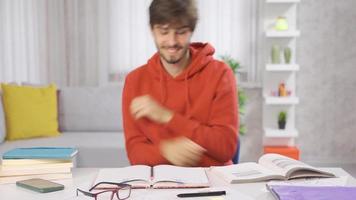 The male student is dancing. Student male. Young man dancing and happy while doing homework at home. video