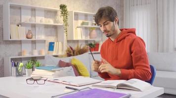 zorgeloos jong Mens dansen terwijl luisteren naar zijn favoriete liedje. ontspannen zorgeloos jong Mens dansen en gelukkig terwijl aan het doen huiswerk Bij huis. video