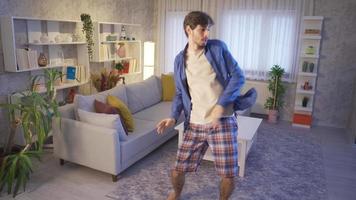 il divertente tipo è provando per danza a casa e è divertimento per lui. giovane uomo danza solo nel moderno Casa e avendo divertimento piace pazzo. movimento telecamera filmato. video