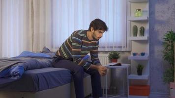 réfléchi malheureux Jeune homme sentiment agité dans le sien chambre. stressé Jeune homme ne peux pas sommeil car il est en pensant et agité. video