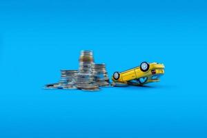A yellow toy car and pile of coins. Concept of a car accident will cost you much money, always be careful when driving.