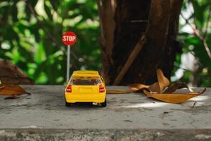 A photo of a yellow toy car meets a stop sign, after some edits.