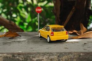 A photo of a yellow toy car meets a stop sign, after some edits.