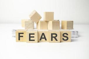 wooden cube block with fears business word on table background. photo