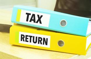 tax return on colourful folders on table photo