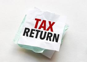 paper with text tax return on white background photo