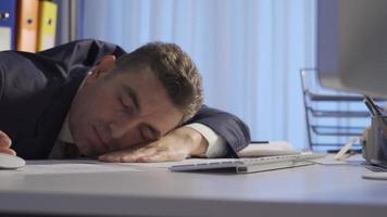empresario quien sucumbido a su dormir. el hombre quien pone su cabeza en el mesa y intentos a dormir cuando él obtiene soñoliento en el oficina. video
