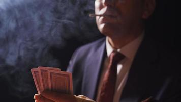 das Reich Geschäftsmann raucht und spielt im das Kasino. cool und stark Geschäftsmann Glücksspiel und Rauchen ein Zigarette. video