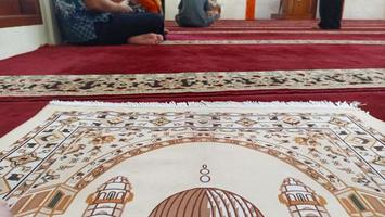 Indonesia - Jakarta, March 17 2023, The atmosphere of people praying on prayer mats and a pulpit in the mosque can be seen. photo