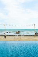 dinning table and chair on beach with sea background photo