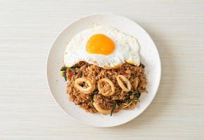 fried rice with squid and basil topped fried egg in Thai style photo