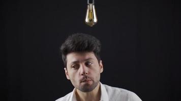 klug Mann kommt oben mit ein Idee, ein symbolisch Idee Lampe Beleuchtung oben über seine Kopf. wann das Mann hat ein Idee, das Birne geht auf über seine Kopf. Brainstorming, kreativ Ideen. video