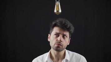 Thinking and finding creative ideas. Idea lamp. The creative man thinks to generate new ideas, and when he comes up with an idea, the lamp above his head turns on. video