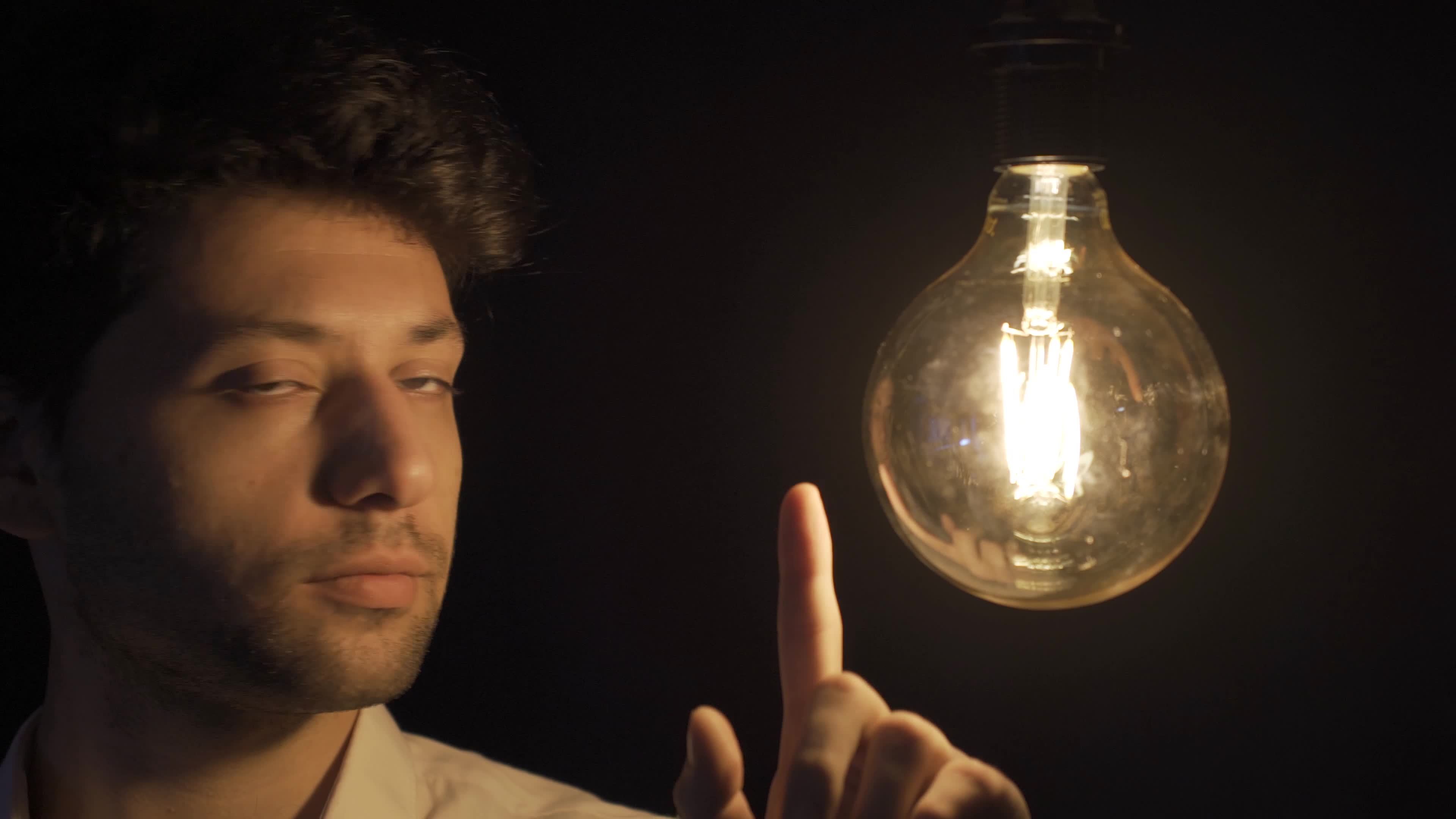 a homem toques a luminária com dele dedo, que significa ele tem a ideia