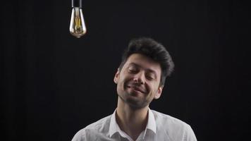 de Mens denkt na, en wanneer de idee komt, de lamp bovenstaand zijn hoofd bochten Aan. eureka. de creatief Mens denkt naar genereren nieuw ideeën, en wanneer hij komt omhoog met een idee, de lamp bovenstaand zijn hoofd bochten Aan. video