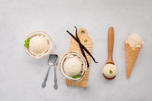 sabores de helado de coco en la mitad de la instalación de coco sobre fondo de piedra blanca. concepto de menú de verano y dulce. foto