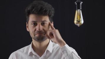 Idea lamp. Happy creative man who came up with an idea. The man shows an idea that comes to his mind by lighting a light bulb. Eureka. video