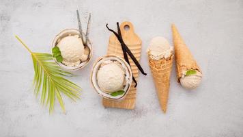 sabores de helado de coco en la mitad de la instalación de coco sobre fondo de piedra blanca. concepto de menú de verano y dulce. foto