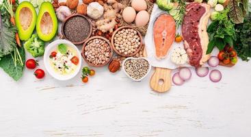 concepto de dieta cetogénica baja en carbohidratos. ingredientes para la selección de alimentos saludables sobre fondo blanco de madera. foto