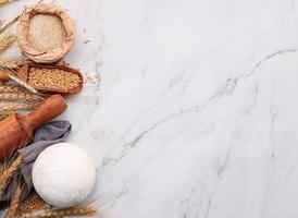 Wheat ears and wheat grains set up on marble background. Top view and copy space photo