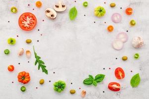 The ingredients for homemade pizza set up on white concrete background. photo