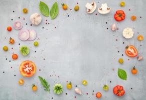 The ingredients for homemade pizza with wooden pizza tray set up on grey concrete background. top view photo