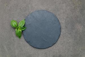 Empty pizza platter for homemade baking set up on dark concrete. Food recipe concept on dark stone background texture with copy space. photo