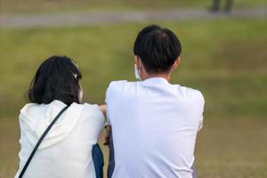 Young couple sitting watching sunset in evening and chatting happily. young couple sits and talks to discuss and express their hearts to each other. concept of love and friendship for each other. photo