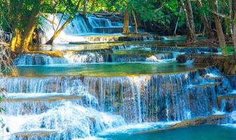 increíble cascada colorida en el bosque del parque nacional durante la primavera, hermoso bosque profundo en tailandia, larga exposición técnica, durante las vacaciones y el tiempo de relajación. foto