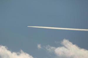 A plane and vapor trails in the sky photo