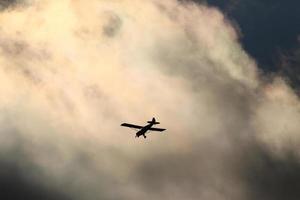 Small plane flying in the sky against dark clouds photo