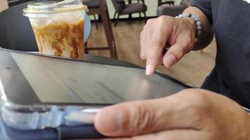 Close up of male hand using tablet in cafe, internet connection to follow and update information News and social media. Lifestyle concept with modern technology on vacation. video