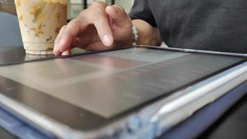 Close up of male hand using tablet in cafe, internet connection to follow and update information News and social media. Lifestyle concept with modern technology on vacation. video