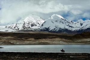 Overlooking the 7,500-meter-high Muztagh Tower from Pamirs Karakul Lake photo