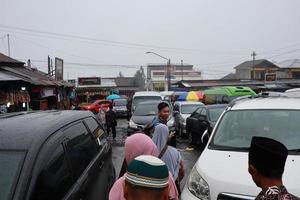Tegal, January 2023. Group photo on the way to Guci tourist spot. with the density of visitors, busy parking vehicles and various kinds of sellers on the side of the road.
