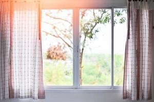 luz de sol mediante en habitación abierto cortinas con balcón y naturaleza árbol en fuera de ventana - dormitorio ventana en el Mañana foto