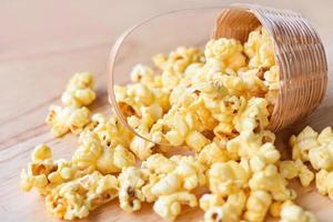 Popcorn in basket and wooden backgroubd - Sweet butter popcorn salt photo