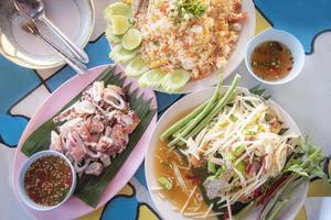 set of food plate with grilled squid , papaya salad , fried rice and chilli sauce food of asia photo