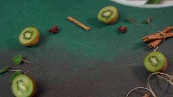 Man's Hand Picks up plate with Slice of Cheesecake with Kiwi. Decorated with cinnamon sticks, badyan, mint leaves video