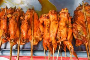 Asian style grilled chicken wing on tray wooden background - Thai roasting chicken skewer sticks photo