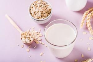 A glass of fresh oat milk and oatmeal. Vegan dairy-free organic drink. photo
